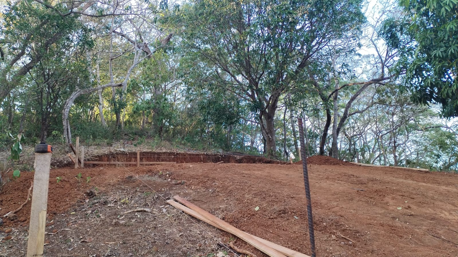 Terreno nivelado con estacas y madera preparado para el inicio de una construcción.